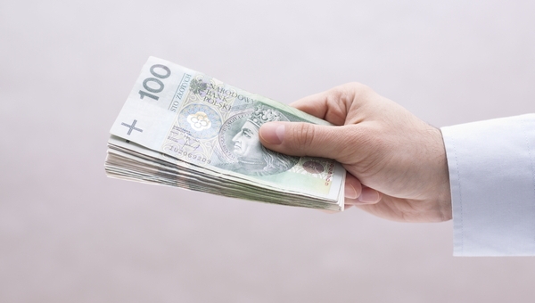 Obraz przedstawia pieniądze trzymane w ręku